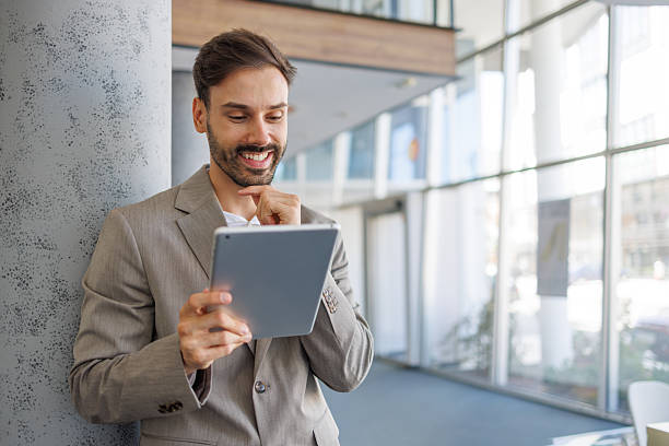 istock Happy businessman smiling and working with digital tablet 2236596552