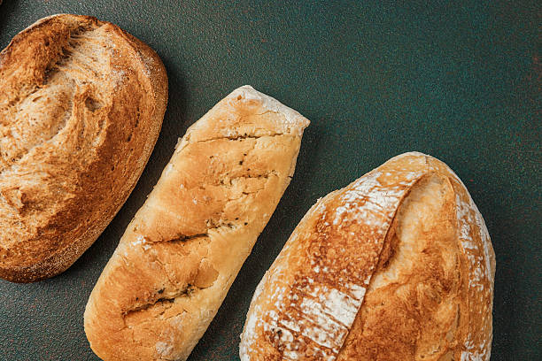 istock Freshly baked artisan bread loaves on a rustic table in a bakery setting 2236596735