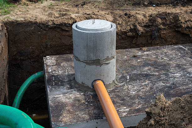istock Concrete sewage system pipe installation in a trench at a construction site. 2236600491