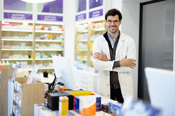 istock Male pharmacist smiling standing at pharmacy counter 2236601690