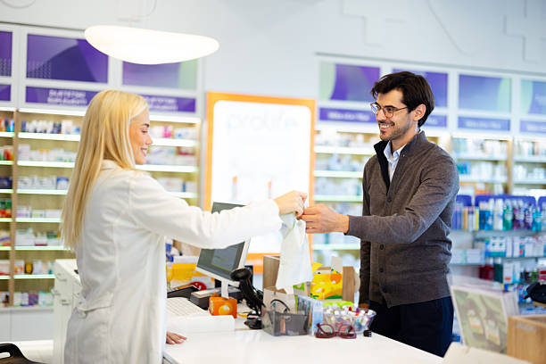 istock Pharmacist handing medicine bag to a smiling customer 2236601770