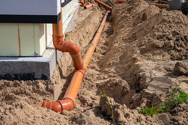 istock Underground drainage pipe installation next to residential building foundation during construction. 2236602141