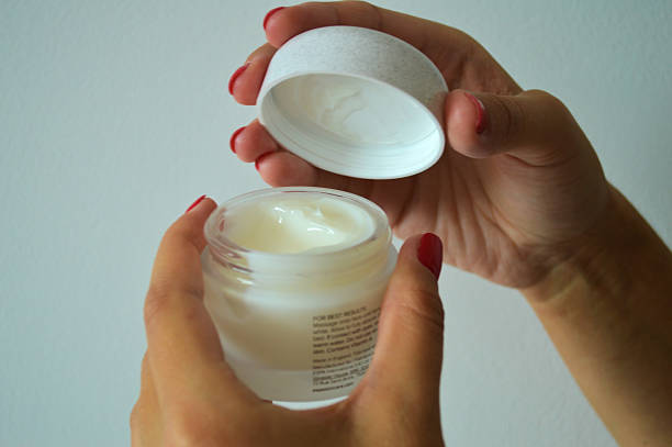 istock Hand Applying Cream from Jar with Red Nail Polish 2236604285