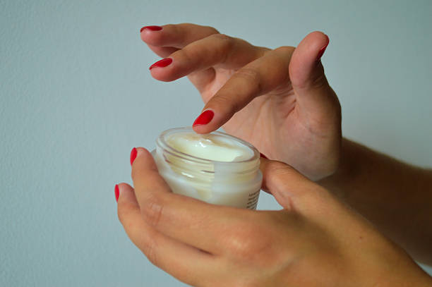 istock Hand Applying Cream from Jar with Red Nail Polish 2236604294
