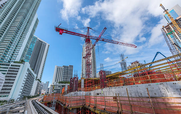 Futuristic view of new downtown Miami buildings next to the free Metromover public transportation system. The image shows a Metromover ramp surrounded by modern skyscrapers.