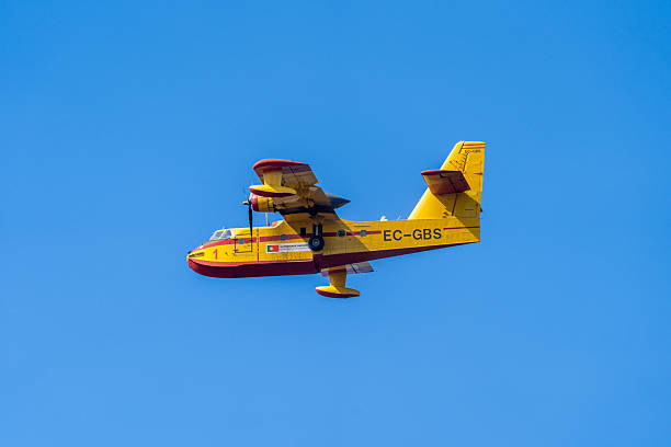 Fire in Aljezur, Portugal on September 21, 2025. A firefighting airplane flying in the sky to get water to drop over a wildfire, surrounded by thick smoke and intense flames. The dramatic scene captures emergency response and natural disaster management, highlighting the scale of the forest fire and the urgent battle to contain it