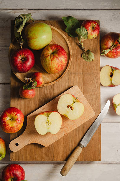 istock Red apples, whole and sliced on a wooden cutting board 2236612134