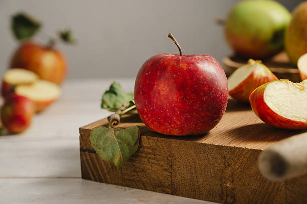 istock Red apples, whole and sliced on a wooden cutting board 2236612149