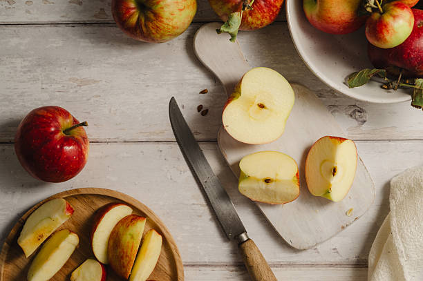 istock Red apples, whole and sliced on a wooden cutting board 2236612153