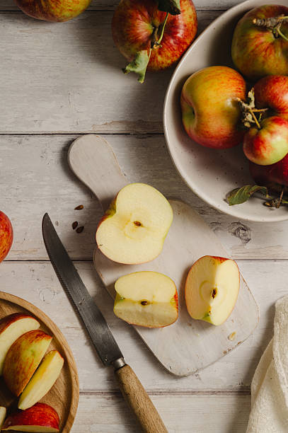 istock Red apples, whole and sliced on a wooden cutting board 2236612156