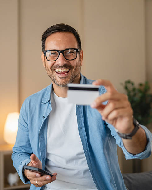 istock Man shopping online using credit card and smart phone at home 2236615677
