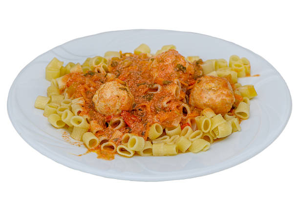 Delicious pasta served with tomato sauce and meatballs on a white plate against a clean white background. Perfect for food photography, Italian cuisine, and menu content.