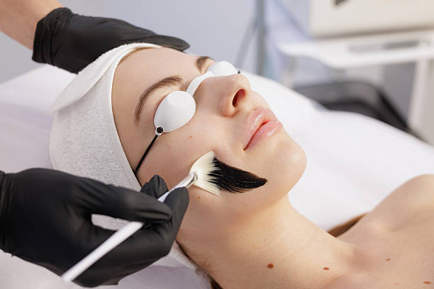 istock Charcoal peel application on face in professional spa clinic 2236622107