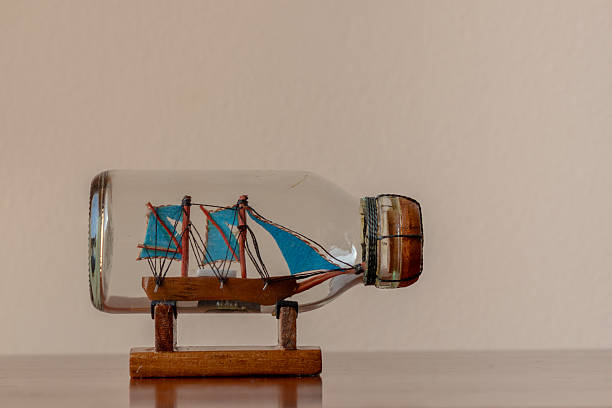 Ship in a Bottle. Small ship model in a bottle with a cork stopper on black background.