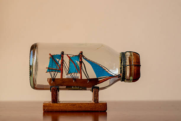 This is a side view close up color photograph of a Message in a Bottle on Sand dune at Sunset