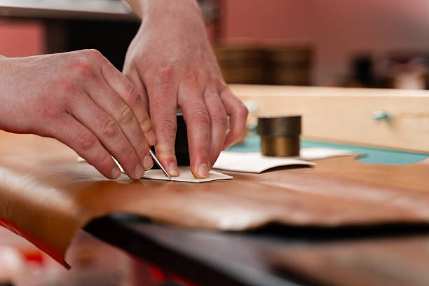 istock Leather crafting process showing precise cutting. Skilled artisan cuts leather with accuracy. Leather Cutting with Pattern. Leather artisan uses templates to cut hides accurately. 2236626004