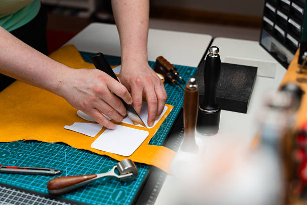 istock Leather crafting with precision knife and templates. Leather Cutting with Knife and Templates. Artisan cuts premium leather with sharp knife and paper templates. 2236626535