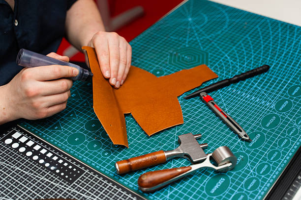 istock Craftsman applies dark edge finish to leather cut, adding strength, smoothness, and sophistication. Edge finishing with dye marker. Artisan applies edge dye to leather piece, enhancing durability. 2236626864