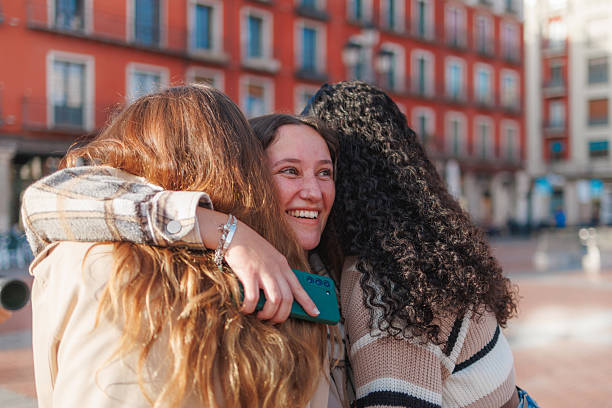 istock Three friends sharing a warm hug in an urban setting, expressing joy and connection 2236626915