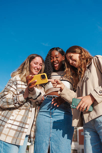 istock Diverse women friends laughing watching smartphone content 2236628005
