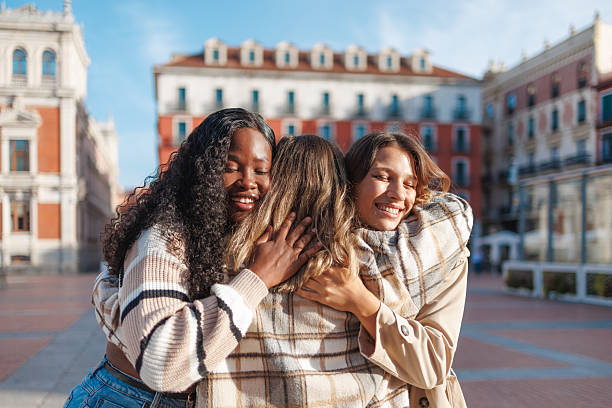 istock Three friends happily hugging on a city square, expressing friendship and joy 2236628698