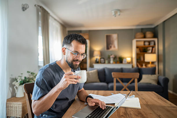 istock Male doctor working remotely from home on laptop 2236633737