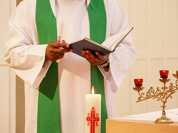 istock Priest holding a liturgical book and candle during a Christian baptism ceremony 2236633819