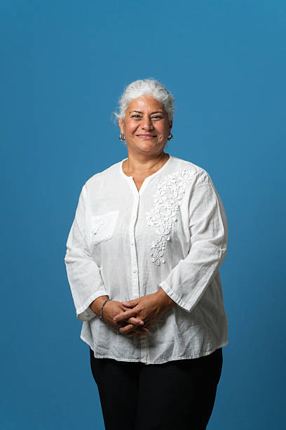 istock Confident senior woman standing with hands clasped against blue background 2236634680