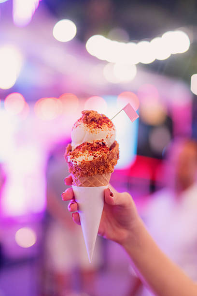 istock Hand Holding a Red Sugar Sprinkled Vanilla Ice Cream Cone 2236649458