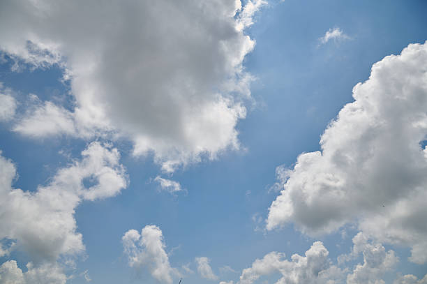 Blue sky showing white cumulus clouds with bright sunlight