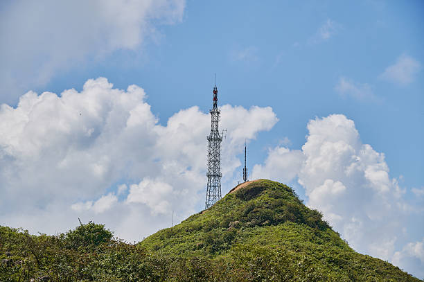 istock Communication towers on a lush green hilltop reaching blue sky 2236651468