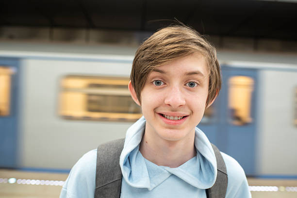 istock Teenage boy in purple clothes with a backpack waiting for a train on a subway platform. 2236652962