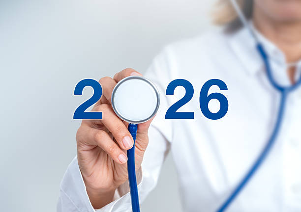 istock Doctor in white coat holding stethoscope with blue number 2026 on white background, symbolizing healthcare goals, medical innovation, healthy new year resolutions, checkup, wellness trends in 2026. 2236656304