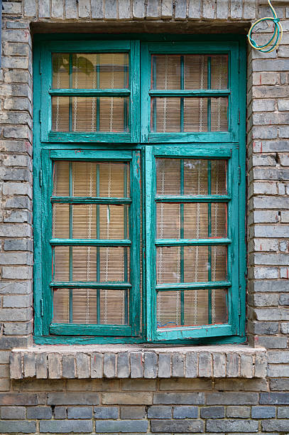 istock Teal old wooden window on brick wall 2236662699