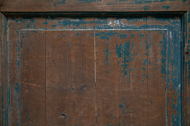 Old wood surface showing textured grain and chipping teal colored paint
