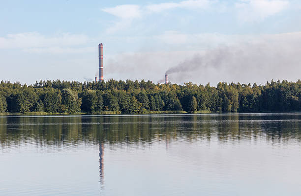A large power plant is visible in the distance. The smoke from the plant is rising into the sky