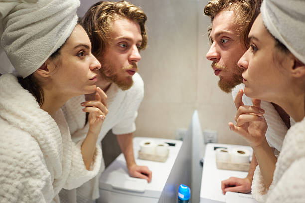 Back of a squash player urinating in his gym bathroom. Behind a fit man taking a break to urinate. Athletic man taking a break from his match to urinate in his gym toilet