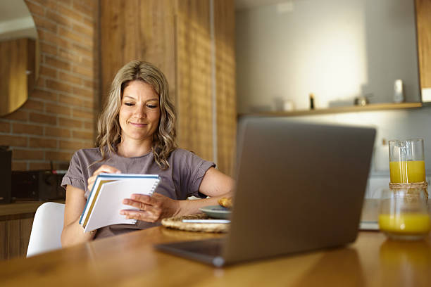 istock Smiling woman taking notes at home. 2236669961