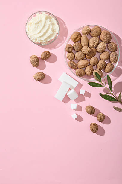 istock Shea butter cubes, cream and nuts decorated with plenty of empty pink background. Clean layout for packaging mockup or wellness ad visuals. Copy space 2236673407