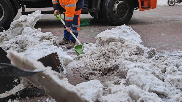 istock Municipal worker removing snow with shovel from road after snowstorm 2236673633