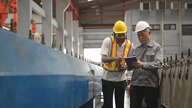 istock Senior engineers and young man workers are talking and inspecting machines on a production line 2236673684