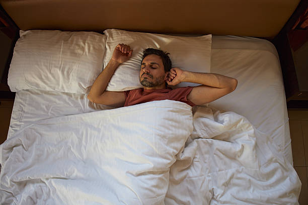 istock Man peacefully stretching in the bed 2236674664