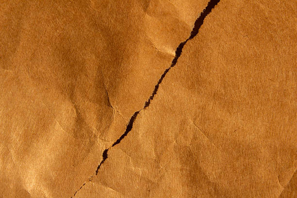 istock Brown crumpled creased paper background texture 2236674695