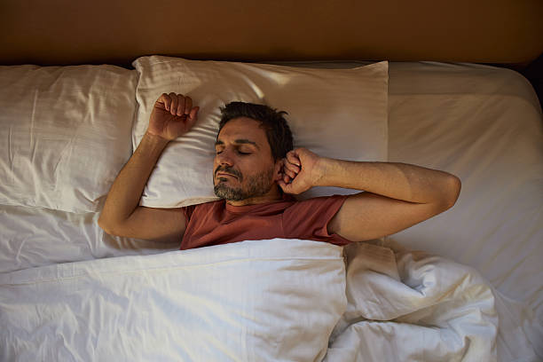 istock Man peacefully stretching in the bed 2236674774
