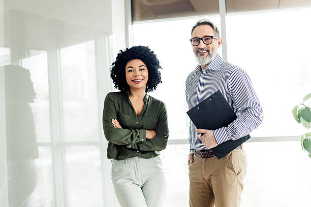 istock Professional colleagues standing together in modern office smiling confidently, showcasing teamwork and cooperation 2236677510