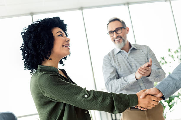 istock Business professionals collaborating at a corporate office, with executives shaking hands and fostering teamwork 2236677636
