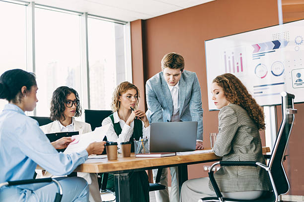 istock Meeting at an Elegant Office Featuring Professional Team in Formalwear Collaborating on a Diverse Business Project 2236678253