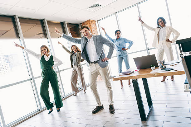istock Business Team Celebrating Success with Dynamic Poses in Modern Office Setting, Showcasing Professionalism and Teamwork 2236678293