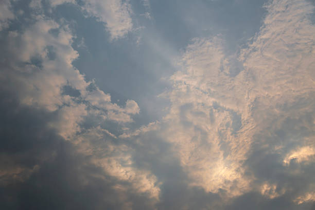 Dramatic grey sky with muted sunlight halo and layered storm clouds in Irish weather