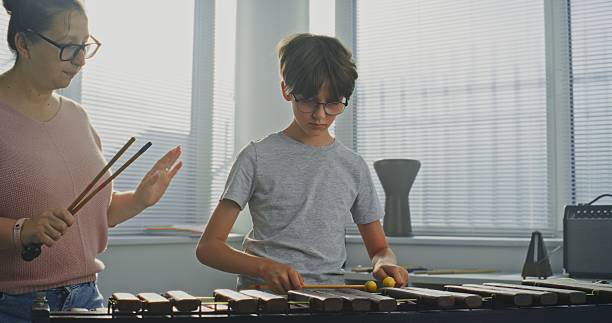 Talented Boy Playing Xylophone During Music Lesson. Teacher Teaching Young Musician